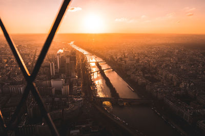 High angle view of river amidst buildings in city at sunset