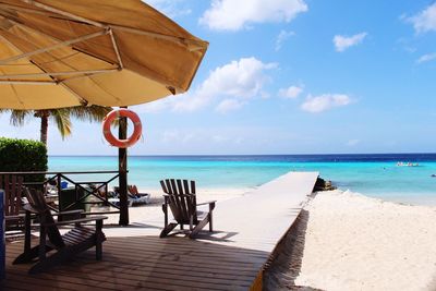 Scenic view of beach against cloudy sky