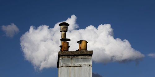 Smoke emitting from chimney against sky