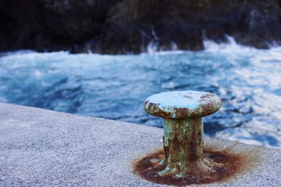 Close-up of metal against sea