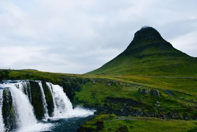 Scenic view of waterfall against sky