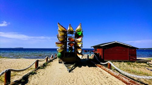 Lifeguard hut on beach against blue sky
