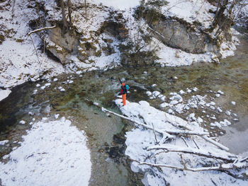 High angle view of man standing on rock by river