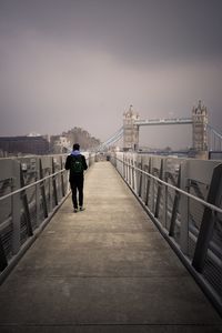 Rear view of man on bridge against sky