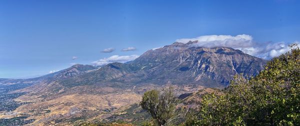 Scenic view of mountains against blue sky