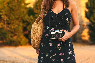 Young female tourist with analogue camera in her hands