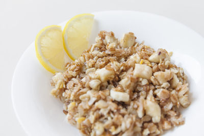 Healthy breakfast, delicious oatmeal with banana and crushed nuts