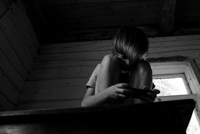 Boy using mobile phone while sitting at home