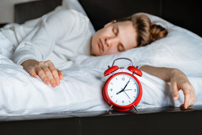 Midsection of woman sleeping on bed