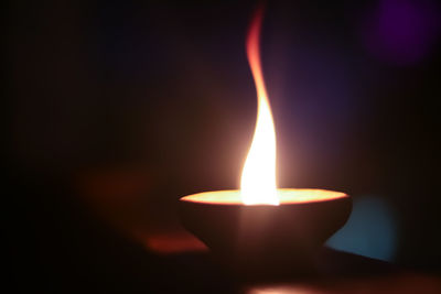 Close-up of lit candle in the dark