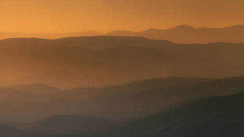 Scenic view of silhouette mountains against sky during sunset