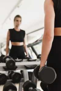 Beautiful woman holding dumbbells at gym