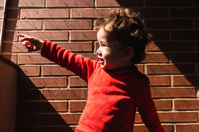 Side view of boy against wall