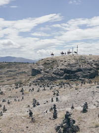 People on rock against sky