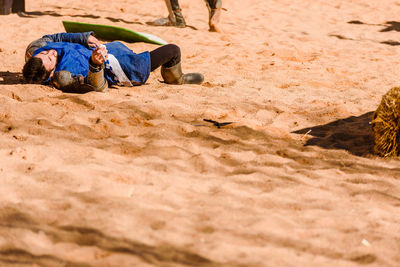 Man lying down on sand at beach