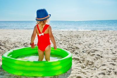 Rear view of woman standing at beach