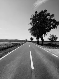 Road by trees against sky