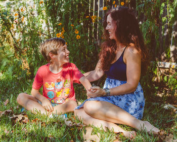 Happy mother with son sitting in park