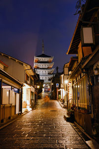 Illuminated alley amidst buildings in city at night