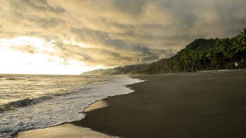 Scenic view of beach against sky during sunset