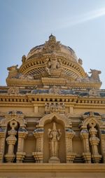 Low angle view of statue of historic building against sky