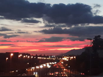 Illuminated city against sky during sunset