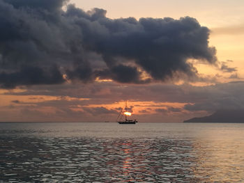 Silhouette ship sailing on sea against sky during sunset