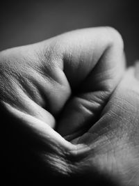 Cropped image of person clenching fist