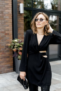 Young woman wearing sunglasses standing outdoors