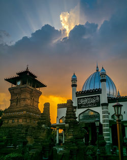 Buildings in city against sky during sunset