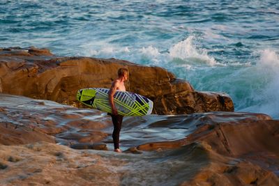 Woman standing on rocks at sea shore