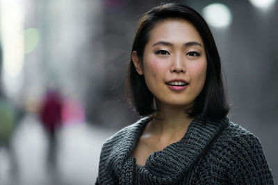 Close-up portrait of smiling young woman outdoors