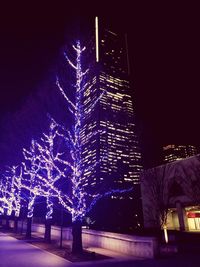 Low angle view of illuminated buildings against sky at night