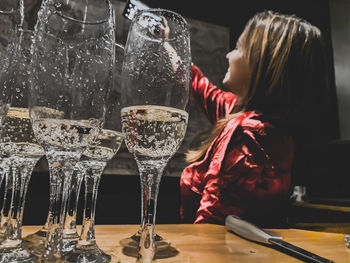 Midsection of woman drinking glass on table