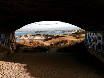 Scenic view of landscape against sky seen through archway