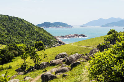 Scenic view of sea and mountains against clear sky