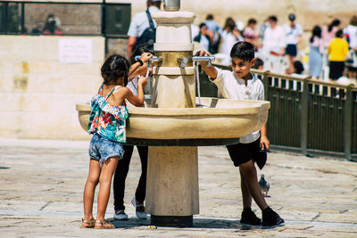 Rear view of people playing in city