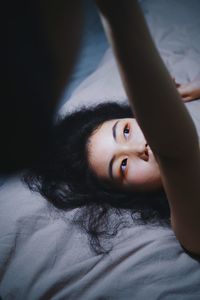 Portrait of woman lying down on bed