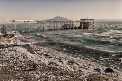 Pier on beach against sky