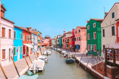 Canal amidst houses against sky in city