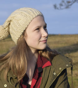 Close-up of girl wearing knit hat in park looking up