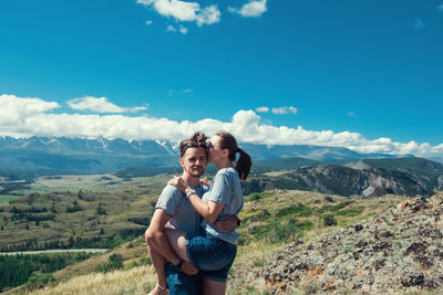 Full length of friends standing on mountain against sky