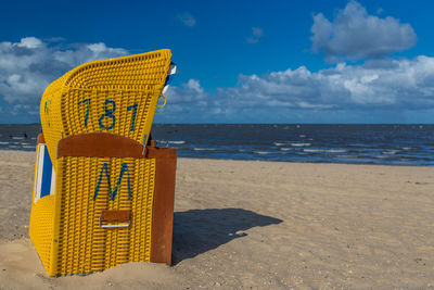Yellow hooded beach chair at beach during sunny day