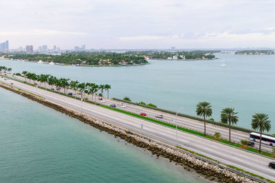 High angle view of city by sea against sky