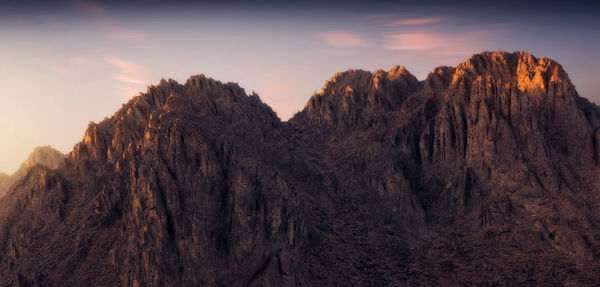 Panoramic view of rocky mountains against sky during sunset