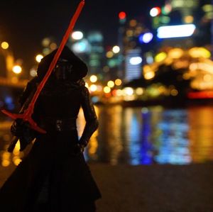 Defocused image of woman standing in city at night