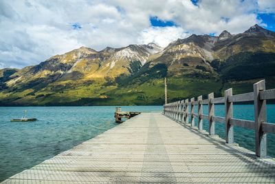 Wooden pier at lake against mountains