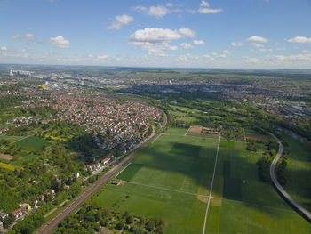 Aerial view of cityscape and farms against sky