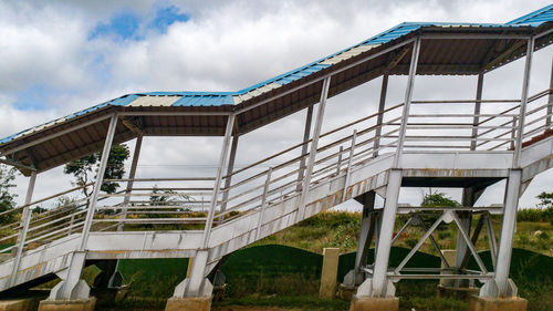 Low angle view of staircase against cloudy sky