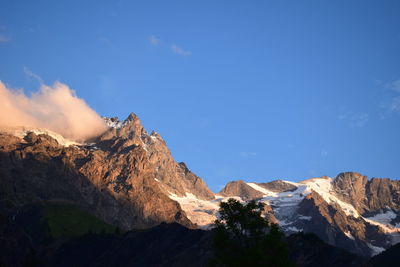 Scenic view of mountains against blue sky